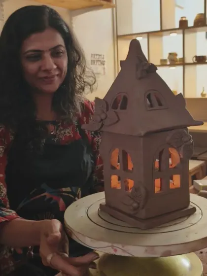 The artist holds her finished lantern with a candle inside, the warm light emphasizing the charming details. It's a magical moment when a creation comes to life.