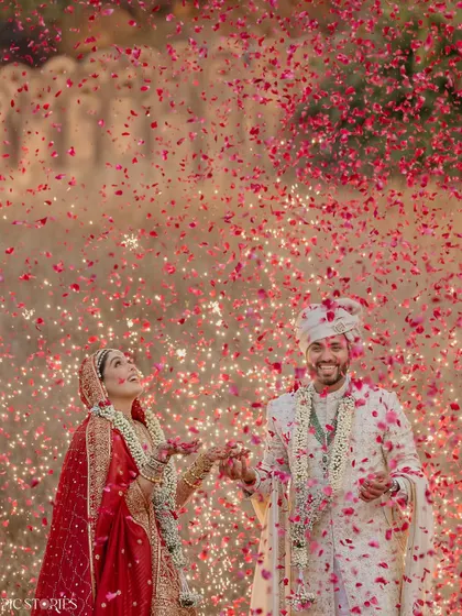 This is the kind of explosive joy I live to capture. Amruta and Jigar, surrounded by a storm of petals and fireworks against a historic fort. This single moment encapsulates the energy and scale of a grand Indian wedding, a celebration of love that is both powerful and beautiful.