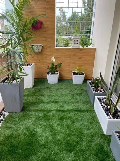 This balcony makeover features a clean layout with artificial grass, modern planters, and pebble borders. We focus on creating organized, low-maintenance designs for busy city life.