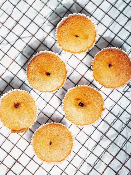 A top-down "flat lay" of freshly baked muffins on a cooling rack. This bright, airy style gives a homemade, authentic feel to the food.
