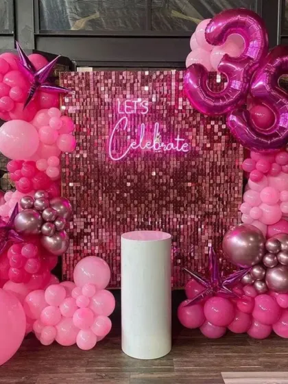 A glamorous "Let's Celebrate" 35th birthday. The pink sequin wall is the star of the show, framed by a stunning arrangement of hot pink and metallic balloons.
