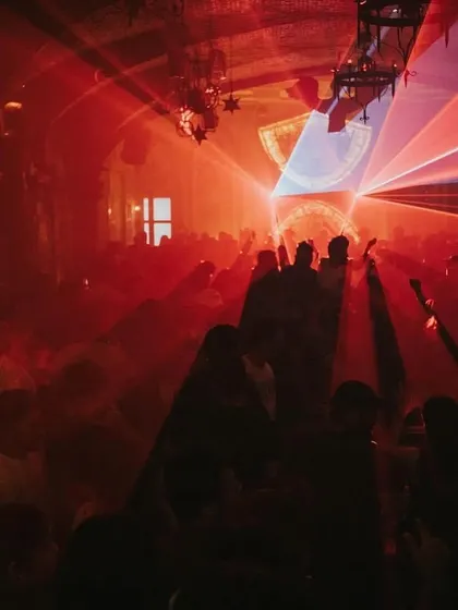 The club is soaked in red light, creating a dark and intense atmosphere perfect for a techno set.