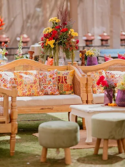 A cozy lounge setup featuring cane furniture and custom-printed cushions. We mixed patterns and colors to create a vibrant, eclectic look that felt like a modern Rajasthani mela.