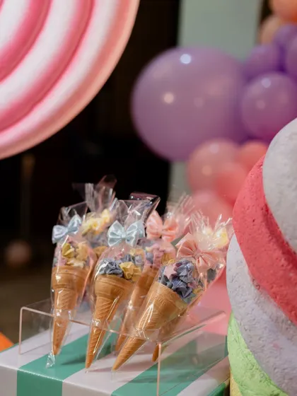 Sweet treats as part of the decor. These ice cream cone-shaped party favors add to the whimsical atmosphere of a Candyland party.