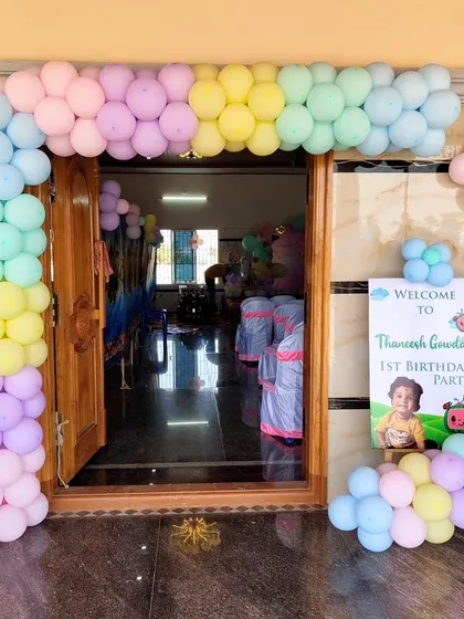 The entrance to a Cocomelon party, featuring a pastel balloon arch and a welcome sign to greet the guests.