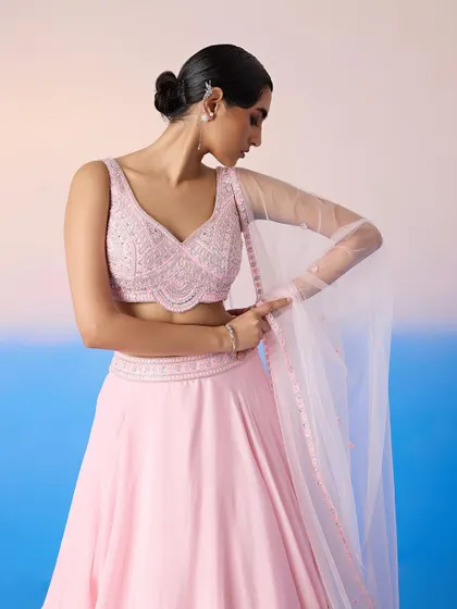 A closer look at the embellished V-neck blouse of the pink lehenga, showcasing the intricate beadwork.