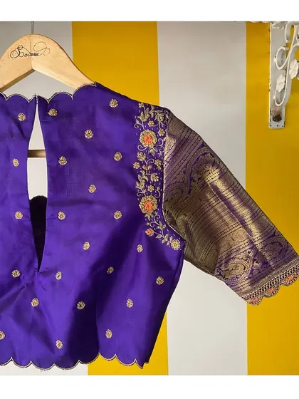 The back of our purple Kanjeevaram blouse, showing the scalloped V-neck cutout and the beautiful contrast of the woven brocade sleeve.