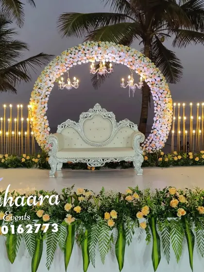 Imagine your reception against the backdrop of the sea. This beautiful beachside setup features a circular floral arch, elegant chandeliers, and candlelit stands, creating a romantic and unforgettable ambiance.