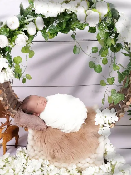 A wider angle of the floral wreath setup, incorporating charming woodland elements like a deer figurine. This shows how we can build a complete, themed scene for your newborn's photoshoot.