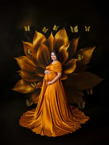 A magical, fine-art portrait featuring a golden-yellow gown, a giant painted flower, and whimsical butterflies.
