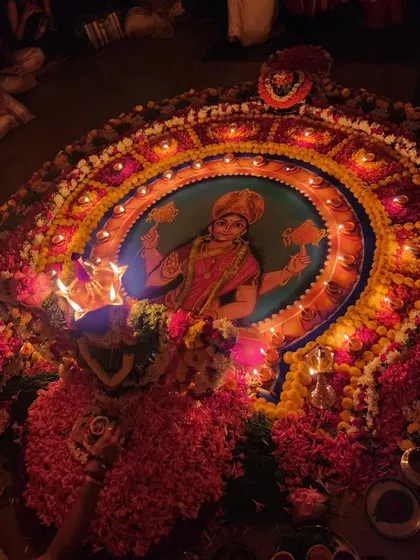 An overview of the Durga Deepa Namaskara pooja setup at night. The glowing lamps around the beautiful rangoli create a mesmerizing and spiritual experience.