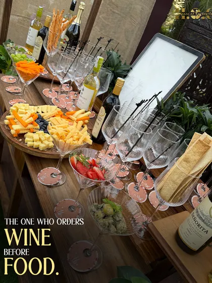 A close-up of my wine and cheese station, perfect for guests who appreciate the finer things. The setup includes a variety of cheeses, crackers, grapes, and of course, a selection of fine wines.