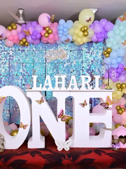 Lahari's first birthday was a sparkling butterfly dream. We used a shimmering blue sequin backdrop, a large "ONE" table, and pastel balloons with gold butterfly accents to create this magical and elegant setup.