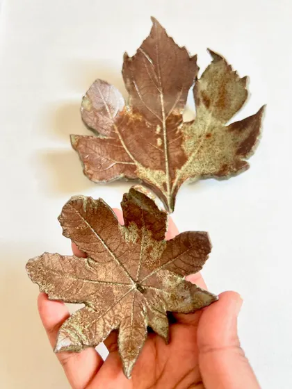 These beautiful leaf-imprinted wall art pieces were made by a student. Real leaves were pressed into the clay to capture their natural texture.