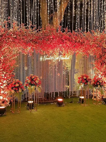 A stunning cherry blossom themed backdrop. We used shades of pink and red, along with a custom neon hashtag, to create this vibrant and modern photo-op for an engagement.
