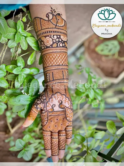 A beautiful engagement mehendi design that extends up the arm, featuring peacocks and intricate bands.