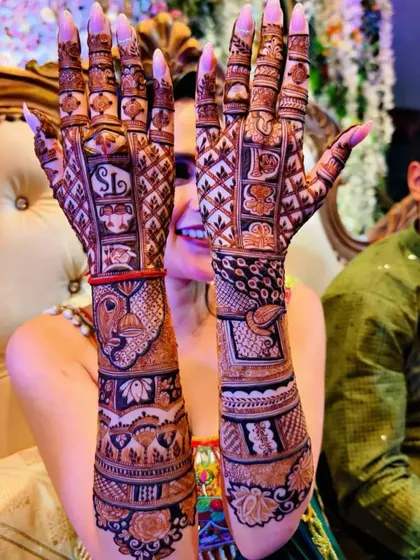 A client showing off her unique design, which includes a traditional mask and peacock motifs.