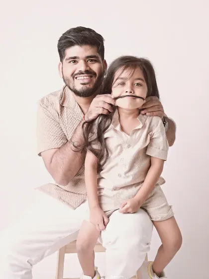 A funny-face moment. This father-daughter portrait, with her hair as a mustache, is a perfect example of their playful relationship.
