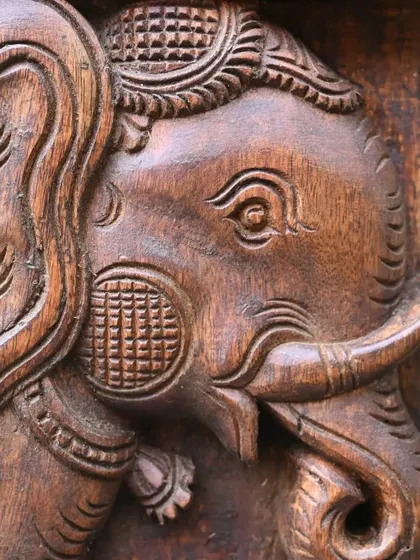 A close-up detail of an elephant carving from a 4-foot Ashta Ganesha vertical panel, showcasing the fine texture and expressive eyes.