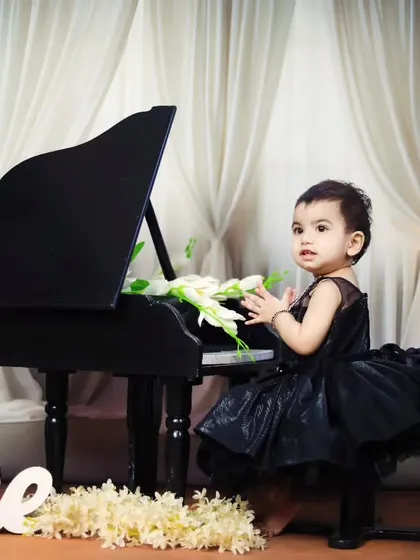 The birthday girl claps her hands with joy during her piano-themed session.