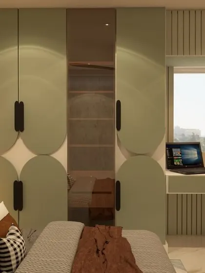 This bedroom design cleverly incorporates a wardrobe with playful, semi-circular patterns and a built-in study desk. The use of a calm green color and natural light makes it a perfect space for both rest and productivity.