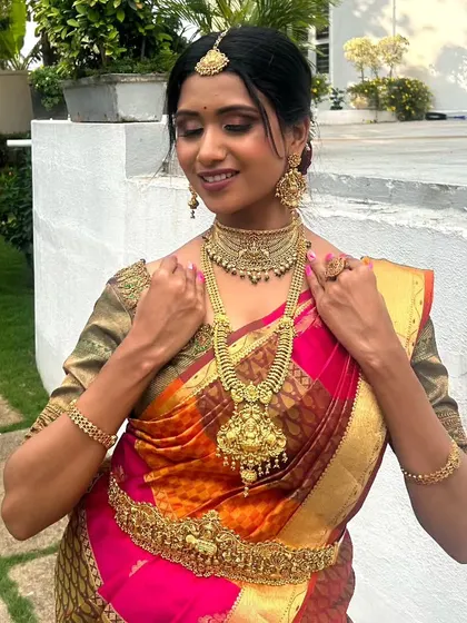 A model posing in a vibrant silk saree, adorned with a full antique gold temple jewellery set.