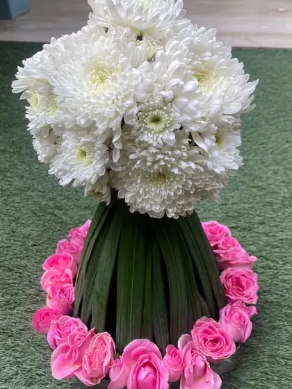 Floral DIYs are a perfect way to add a personal touch and draw the attention of your guests. This topiary-style arrangement of white chrysanthemums and pink roses is both elegant and creative.