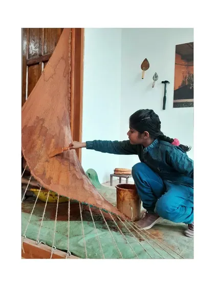 A young participant gets hands-on, plastering our tensile mud installation at the biennale. Our exhibits are designed to be interactive and educational for all ages.