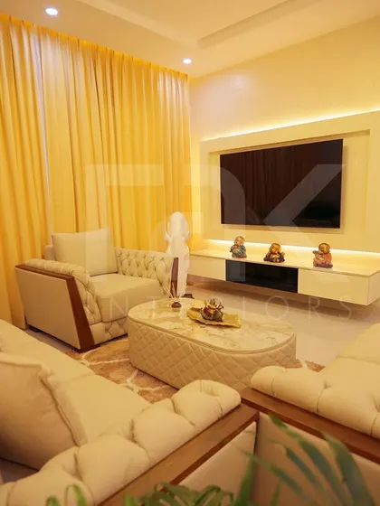 Another angle of the classic living room, highlighting the custom TV unit with backlighting. The quilted coffee table and plush sofas add to the room's opulent and comfortable feel.