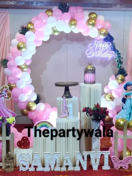 A classic princess theme with a pink and gold balloon arch against a soft pink curtain, perfect for a royal celebration.