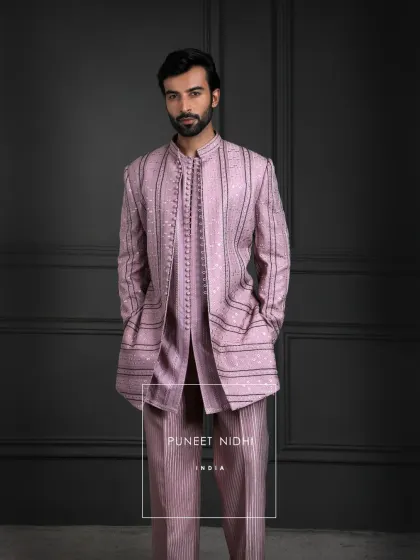 Dusty salmon pink with a subtle sheen, where every fold speaks of grace. This silk blend drapes with richness, adorned with looped buttons and woven stripes.
