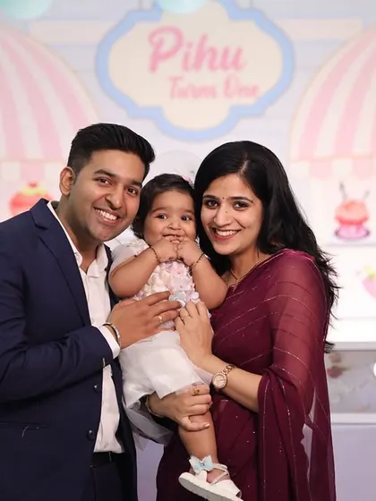 A happy family portrait at a first birthday party with an ice cream shop theme.