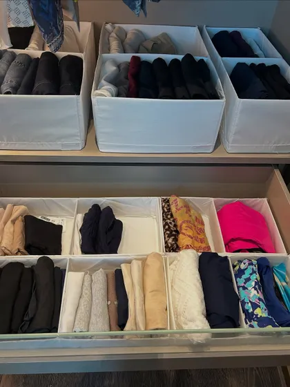 A combination of open bins and drawer dividers creates a highly customized storage solution for different types of clothing.