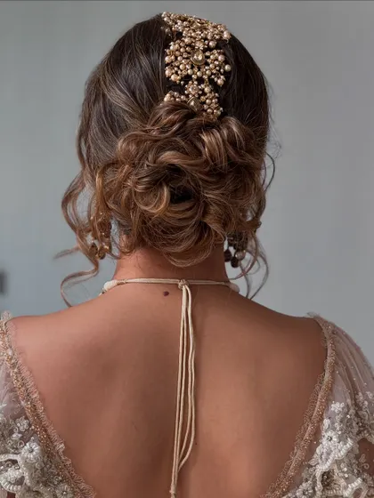 The soft curls and twists of this updo create a dreamy, ethereal vibe.