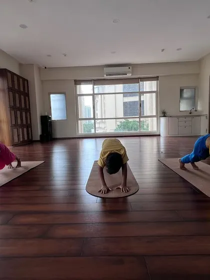 Nurturing mind, body, and spirit with our engaging and playful kids' yoga classes. Here they are, finding their inner puppy in Downward Dog.
