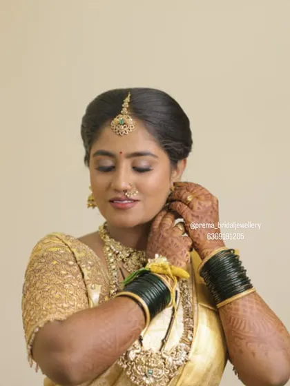 A candid moment of the bride adjusting her earrings. You can see the detail of the Kundan work and the matching green bangles.