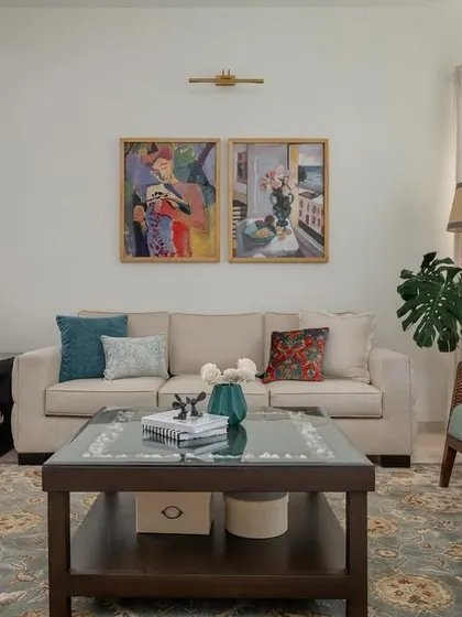 The formal living setting in 'House of Kismish' is designed for conversation, with comfortable sofas, curated art, and plenty of natural light. The space feels both elegant and lived-in.