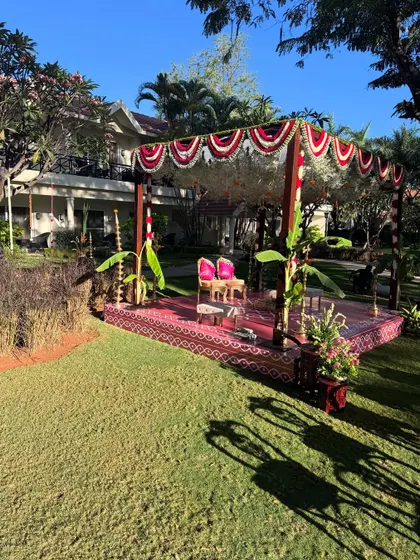 A wide shot of a traditional mandap setup for a Brahmin wedding. The decor features a beautiful blend of cultural elements and natural surroundings.