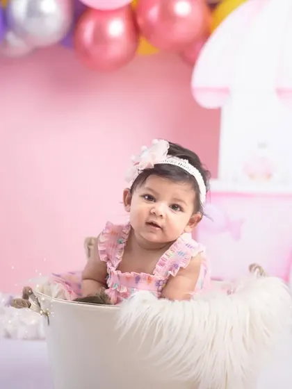 Halfway to one! This little girl is enjoying her Candyland themed sitter session, nestled in a bucket with a soft fur blanket. These sessions are perfect for capturing that proud-to-be-sitting-up stage.