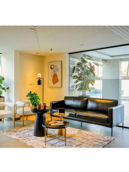 Another view of the lounge area, which overlooks the outdoor pool deck through a large glass wall, seamlessly connecting the indoor and outdoor spaces.
