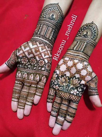 A traditional full-hand design with beautiful symmetry. The patterns include peacocks in mandalas, lotus flowers, and intricate check-work, creating a rich and classic bridal look.