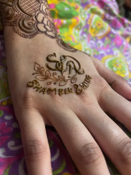A close up of the fresh henna paste for the personalized initials. The clean lines ensure the names are clear and beautiful.