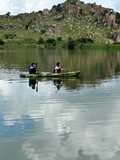Two people kayaking together, with their reflection in the calm water. It's a great team-building and fun activity.