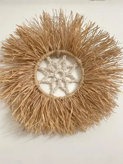 A full view of the handmade raffia wall hanging. This piece is perfect for anyone who loves sustainable, rustic, and bohemian style decor.