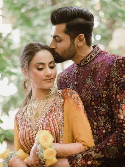 A romantic portrait of Bhavita and Niel from their Haldi day, surrounded by lush greenery.