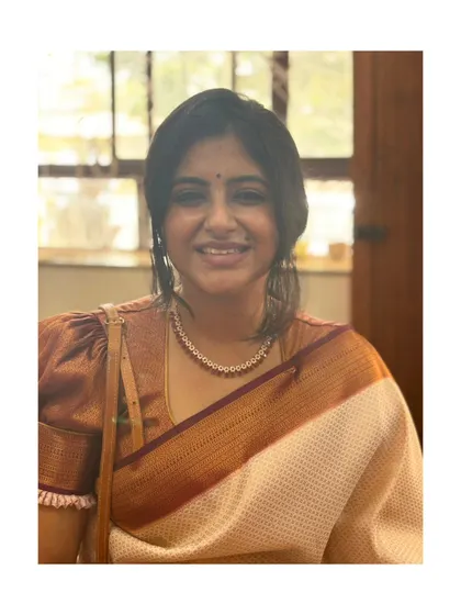 A close-up portrait in a traditional silk saree.