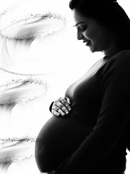 A soft and dreamy black and white close-up. The gentle smile and the hand on the belly are enhanced with a subtle light effect, adding a touch of magic to this intimate portrait.