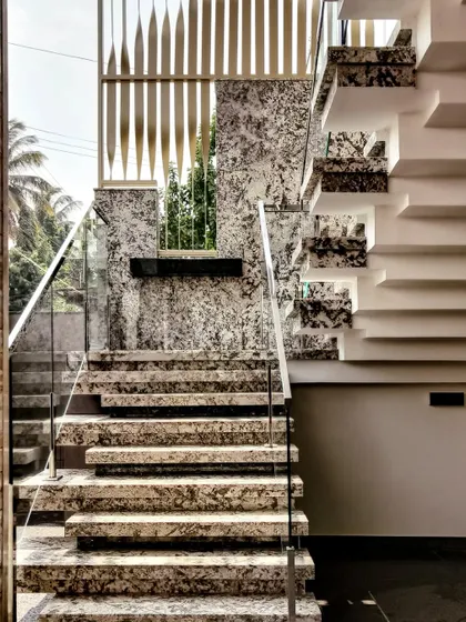 God is in the details. This exterior staircase for the 'House Reversed' project in Hassan showcases my passion for materials, featuring Bianco and Blue Pearl granite steps with a modern glass handrail for a truly luxurious entrance.