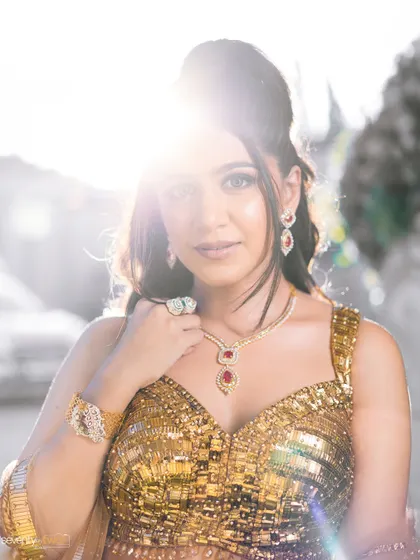 A beautiful backlit portrait of the bride, the sun creating a halo effect around her as she gazes at the camera.