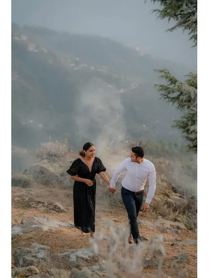 A couple walking hand-in-hand through a misty, atmospheric landscape. This shot has a cinematic and adventurous feel, perfect for a mountain pre-wedding story.